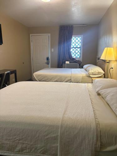 a bedroom with two beds and a window at SE'Air Motel By Townhouse Corpus Christi - Padre Island Tx in Corpus Christi