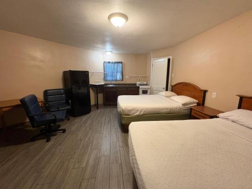 a hotel room with two beds and a desk at SE'Air Motel By Townhouse Corpus Christi - Padre Island Tx in Corpus Christi