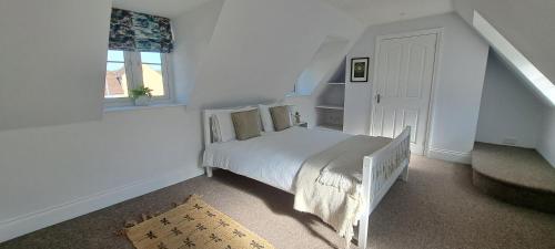 a white bedroom with a bed and a window at Immense 6 bed with massive garden right on A1 in Holme
