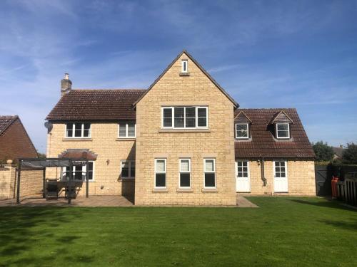 a large brick house with a grass yard at Immense 6 bed with massive garden right on A1 in Holme