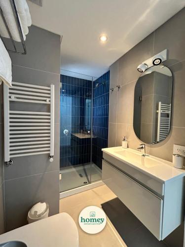 a bathroom with a shower and a sink and a mirror at HOMEY Departamentos in Mar del Plata
