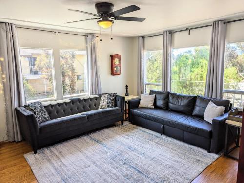 ein Wohnzimmer mit 2 Ledersofas und Fenstern in der Unterkunft Large 3 Bedroom near everything in San Diego in San Diego