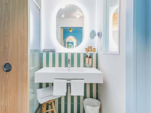 a bathroom with a sink and a mirror at Mercure Président Biarritz Plage in Biarritz