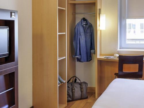 a room with a closet with a blue jacket in it at ibis Konstanz in Konstanz