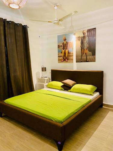 a bedroom with a large bed with green sheets at Nautical Nest Apartments in Malindi