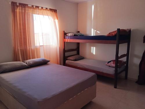 ラゴイーニャにあるRecanto dos Borgesの二段ベッド2台と窓のある寝室