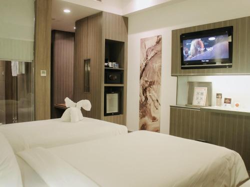 a hotel room with two beds and a flat screen tv at Novotel Bangka Hotel & Convention Center in Pangkalpinang