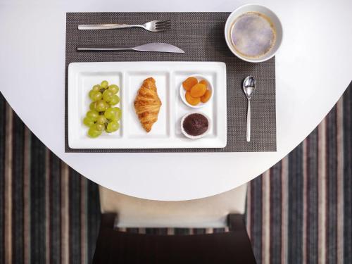 a plate of food with fruit on a table at Novotel Bangka Hotel & Convention Center in Pangkalpinang