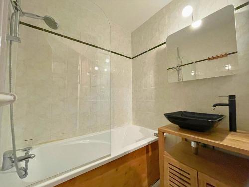 a bathroom with a tub and a sink and a shower at Appartement aux Menuires avec cuisine équipée, balcon et animaux admis - FR-1-452-15 in Les Menuires