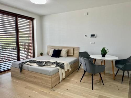 a bedroom with a bed and a table and chairs at Zwirn Bratislava in Nivy