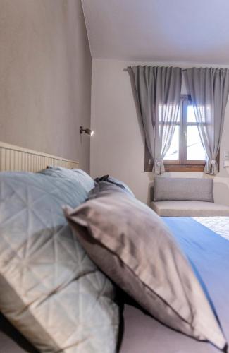 a bedroom with a bed with pillows and a window at Meteora Living Rooms in Kastrákion