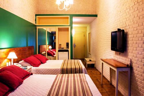 a hotel room with two beds and a tv at Hotel Resort e Golfe Clube dos 500 in Guaratinguetá