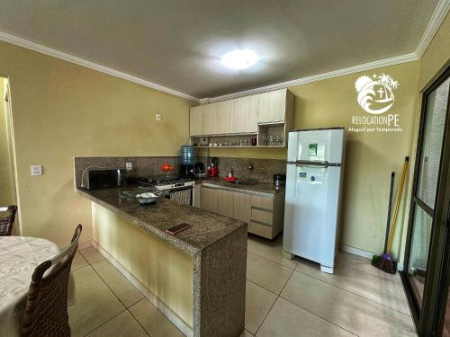 a kitchen with a refrigerator and a counter top at Hotel Canariu's Gravatá - Flat térreo com duas suítes (até 8 pessoas) in Algodões