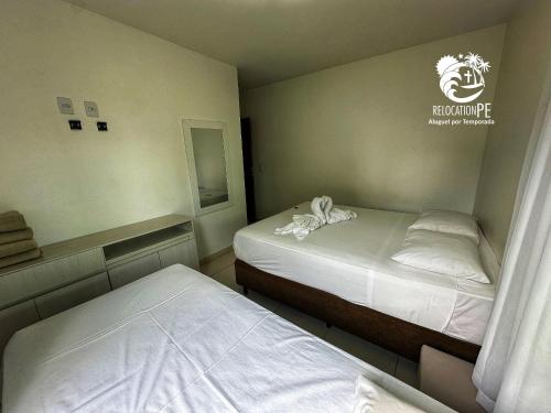 two beds in a small room with two bedsvisor at Hotel Canariu's Gravatá - Flat térreo com duas suítes (até 8 pessoas) in Algodões