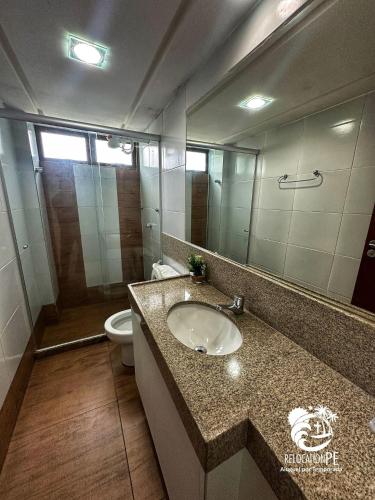 a bathroom with a sink and a toilet and a mirror at Hotel Canariu's Gravatá - Flat térreo com duas suítes (até 8 pessoas) in Algodões