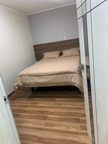 a small bedroom with a bed and a wooden floor at Hotel Huancayo - El Toro Wanka in San Antonio