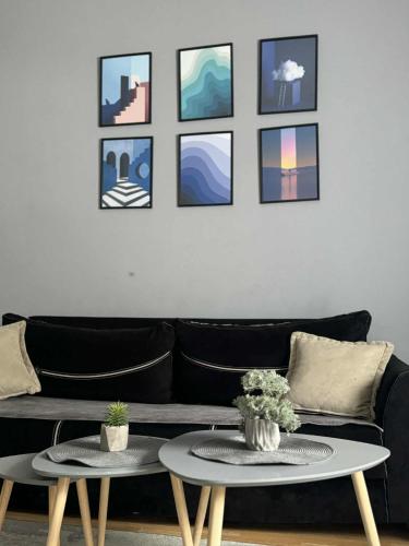 a living room with a black couch and two tables at napartmentss in Pristina