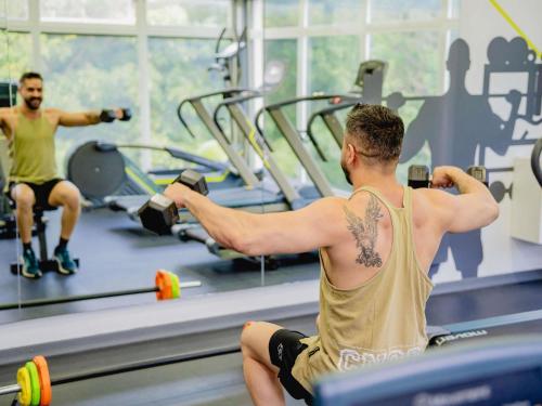 two men exercising in a gym with weights at ibis Asuncion in Asuncion