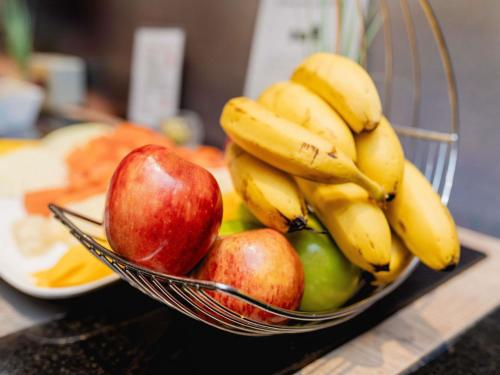 a bowl of apples and bananas on a table at ibis Asuncion in Asuncion