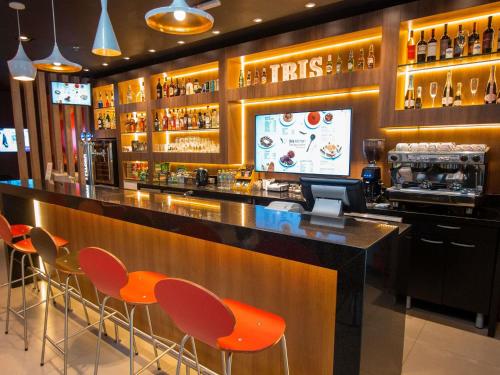 a bar with orange chairs in a restaurant at ibis Asuncion in Asuncion