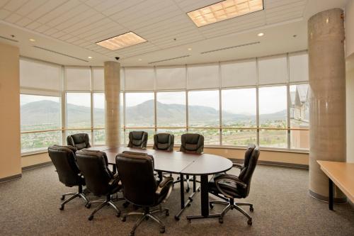 a conference room with a table and chairs in front of windows at Residence & Conference Centre - Kamloops in Kamloops
