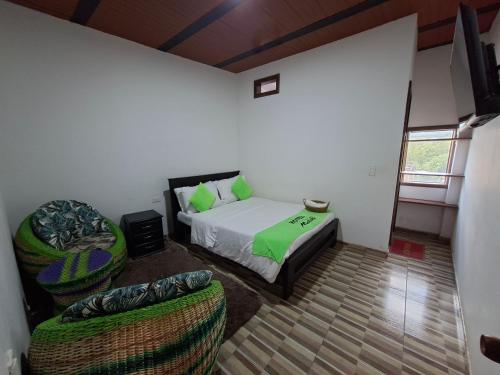 a bedroom with a bed and two chairs in it at Hotel Malaki in San Agustín