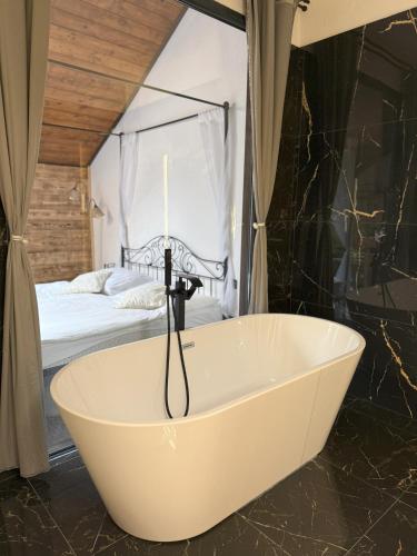 a bath tub in a bedroom with a bed at Hotel Plzeňský Dvůr in Frýdek-Místek