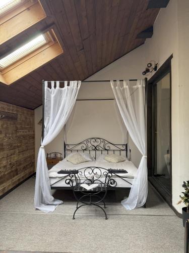 a bedroom with a bed with curtains and a chair at Hotel Plzeňský Dvůr in Frýdek-Místek