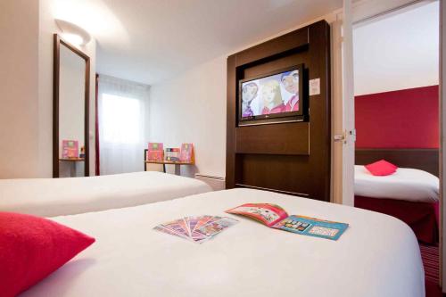 a hotel room with two beds and a television at ibis Styles Belfort Centre in Belfort