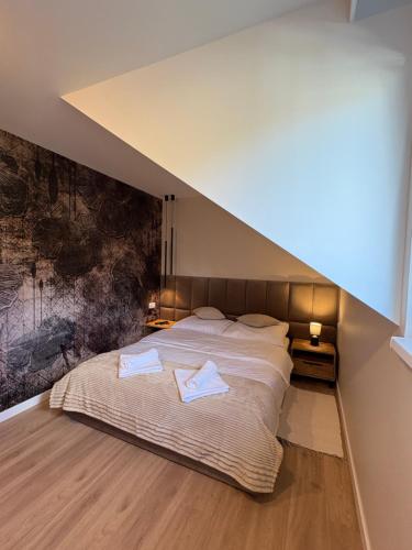 a bedroom with a bed with two towels on it at Babia Perła Zawoja in Zawoja