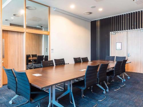 a conference room with a wooden table and chairs at Aparthotel Adagio Liverpool City Centre in Liverpool