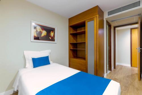 a bedroom with a large bed and a closet at Wyndham Sao Paulo Ibirapuera Convention Plaza in Sao Paulo