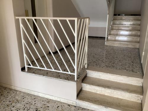 ein Treppenhaus mit weißem Geländer und Stufen in der Unterkunft Quartier piscine municipale Bel Appart 4 pers terrasse parking wi-fi in Vence