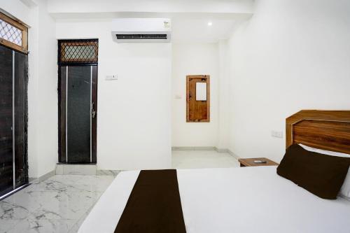 a white bedroom with a bed and a window at Hotel O Vrindavan Gardan & Hotel in Prayagraj