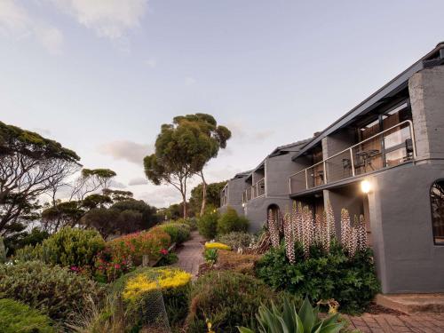a building with a garden of flowers and plants at Mercure Kangaroo Island Lodge in American River