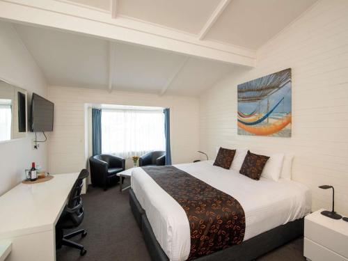 a hotel room with a bed and a desk and chair at Mercure Kangaroo Island Lodge in American River