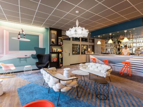 a waiting room with white chairs and a bar at ibis Styles Bordeaux Centre Mériadeck in Bordeaux
