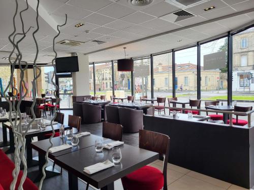 a dining room with tables and chairs and windows at ibis Styles Bordeaux Centre Mériadeck in Bordeaux