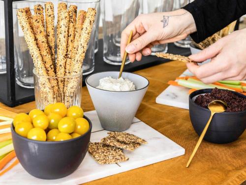 a person is preparing food on a table with snacks at ibis Styles Bordeaux Centre Mériadeck in Bordeaux