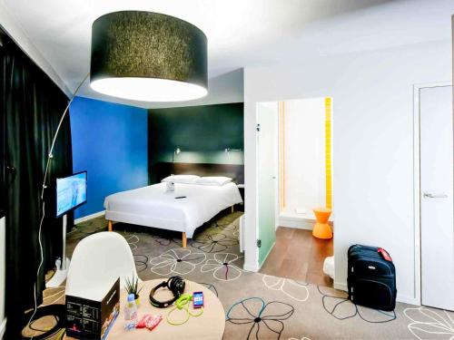 a bedroom with a white bed and a blue wall at ibis Styles Brest Centre Port in Brest