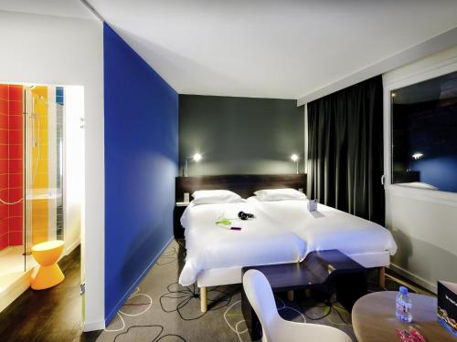 a bedroom with a large white bed and a blue wall at ibis Styles Brest Centre Port in Brest