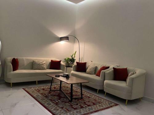 a living room with two couches and a coffee table at شقق الوسام الفندقية in Hafr Al Baten