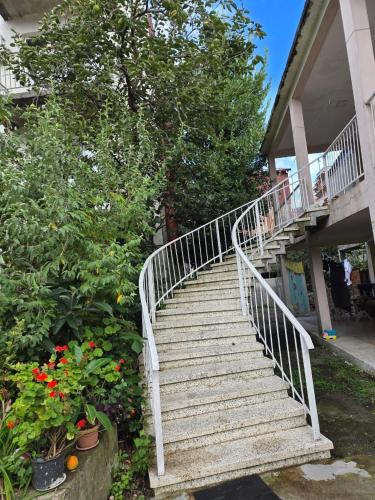 Un escalier blanc mène à une maison fleurie. dans l'établissement Family house in Kobuleti, à Kobuleti