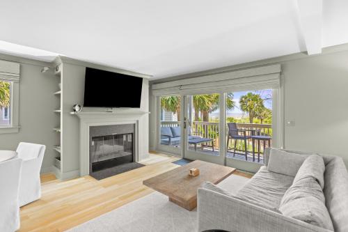 a living room with a fireplace and a tv at New Listing! Seagrove Villa 3A - Luxurious Ocean View! in Isle of Palms