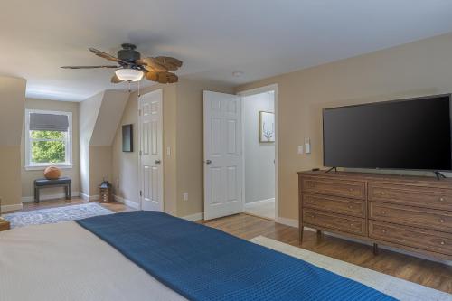 a bedroom with a flat screen tv on a dresser at Game On! 4br Near Acadia Wfire Pit, Games & More in Ellsworth