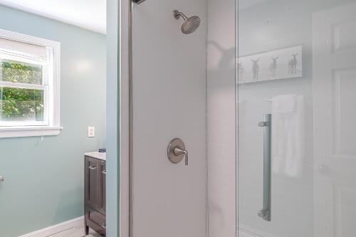 a shower with a glass door in a bathroom at Game On! 4br Near Acadia Wfire Pit, Games & More in Ellsworth