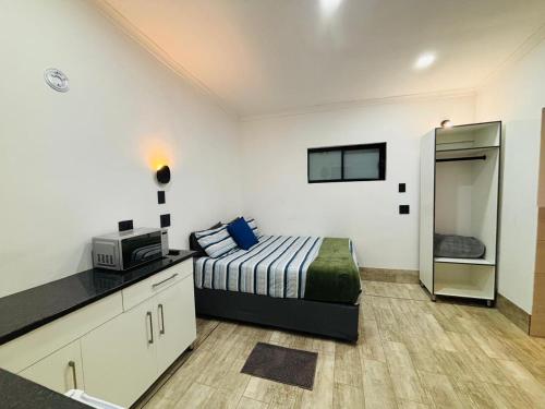 a bedroom with a bed and a microwave in it at East Park Inn in Polokwane