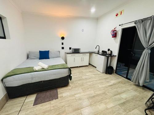 a bedroom with a bed and a small kitchen at East Park Inn in Polokwane