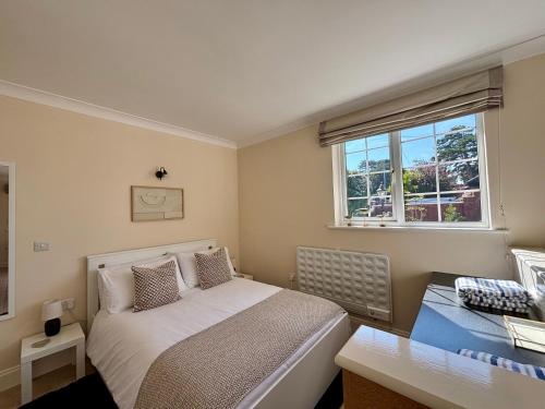 a bedroom with a bed and a desk and a window at Seagulls Rest - Sheringham in Sheringham