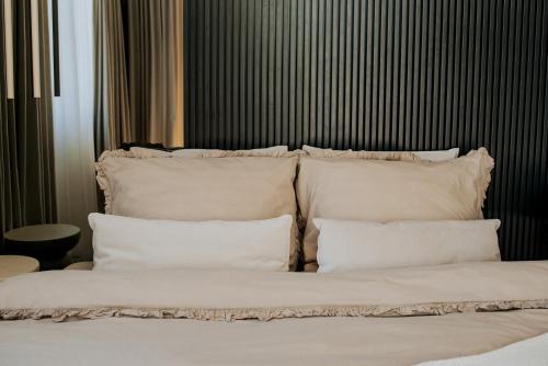 a bed with white pillows on top of it at By the lake apartment in Ostróda